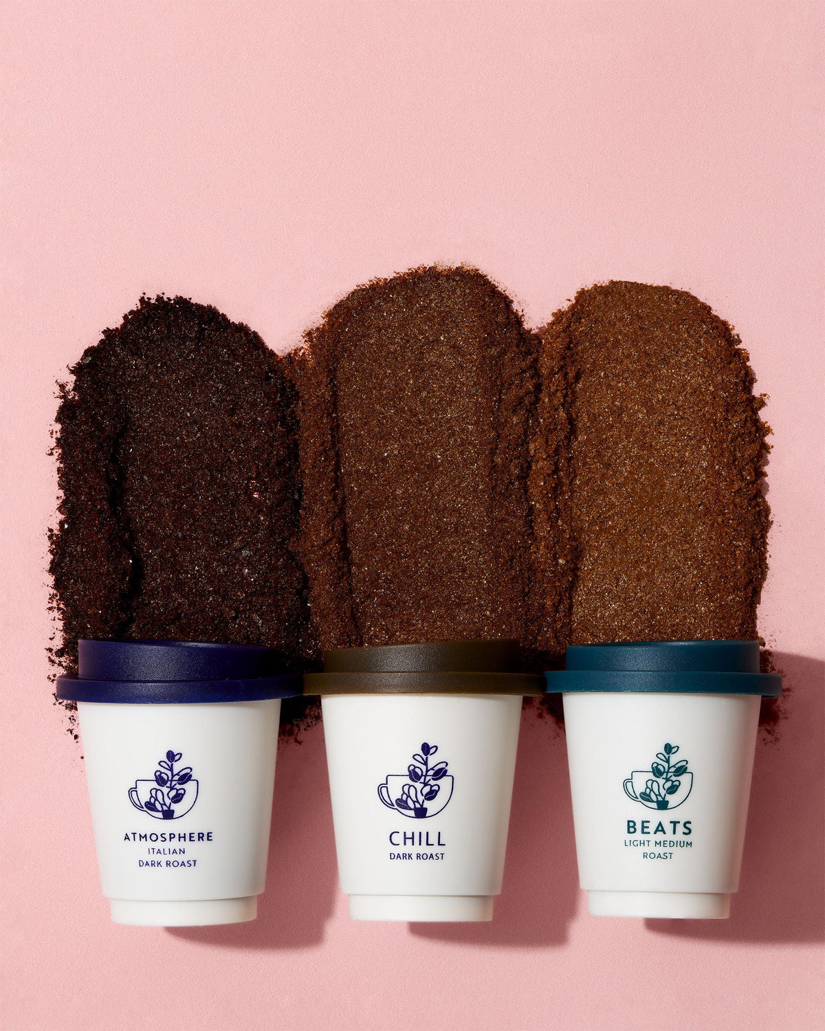 Three coffee capsules with labels 'Atmosphere', 'Chill', and 'Beats' on a pink background
