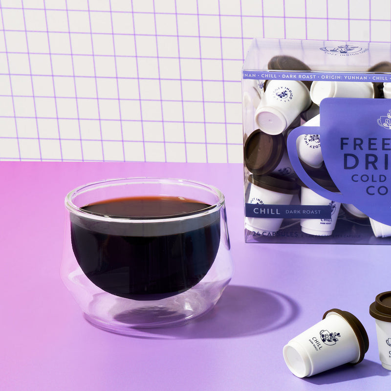 Dark coffee cup with capsules on pink-purple gradient | Cozy Indigo Coffee