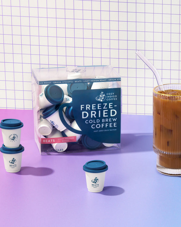 Package of BEATS freeze-dried cold brew coffee with a glass of iced coffee on a grid background
