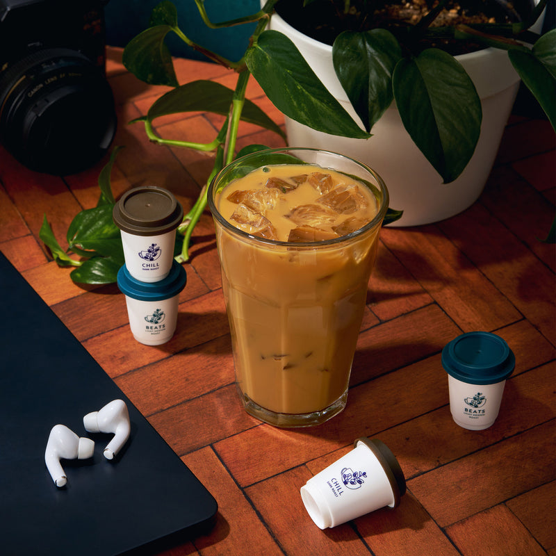 Iced coffee on wooden table with trinkets and plant | Cozy Indigo Coffee