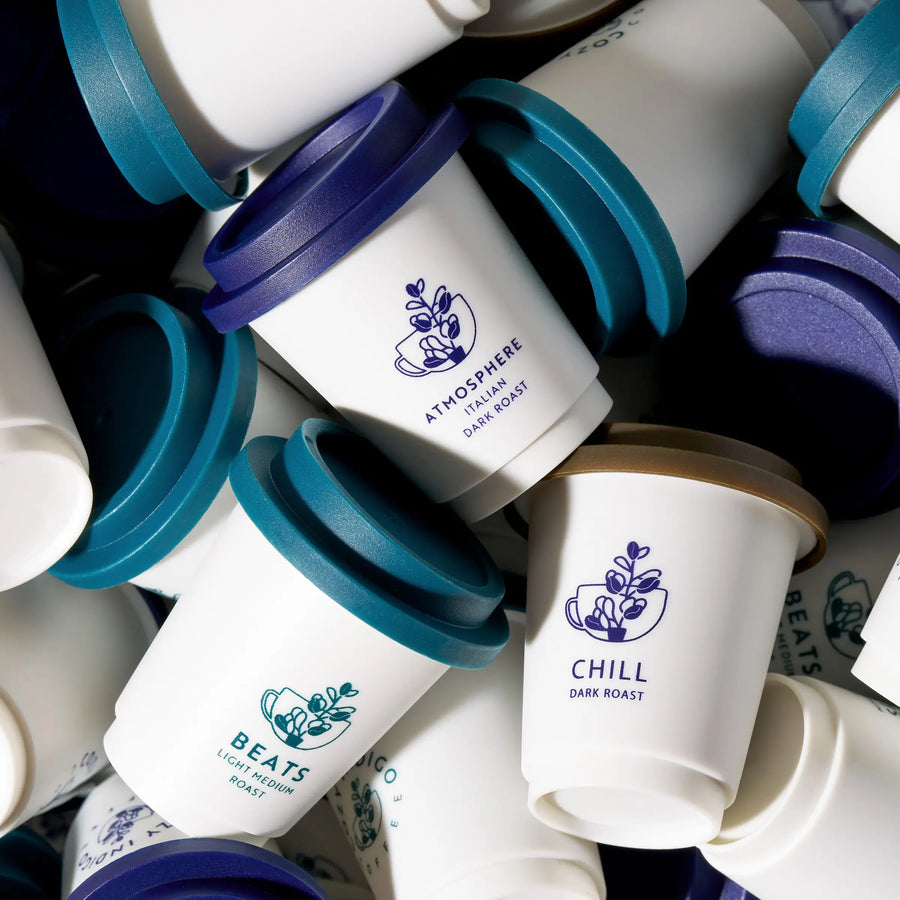 Stack of Cozy Indigo Coffee capsules with visible branding on cups