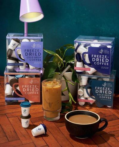 Cold brew boxes with mugs, iced coffee, and plant | Cozy Indigo Coffee